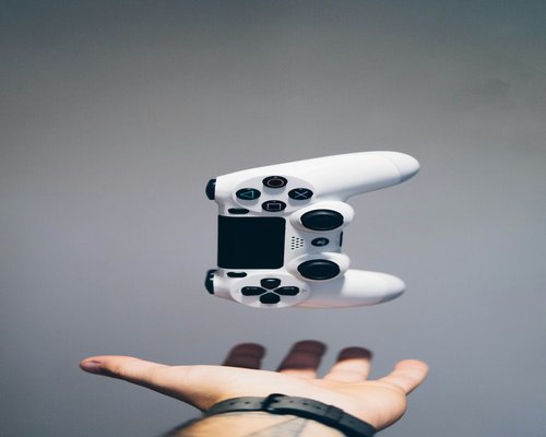 Close up of a person holding a gaming console controller